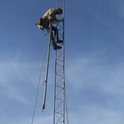 Ten feet at a time, the tower slowly rises up into the air. Leonard Smith is using a "gin pole" to help pull sections up to the top of the tower, where they are then bolted into place.