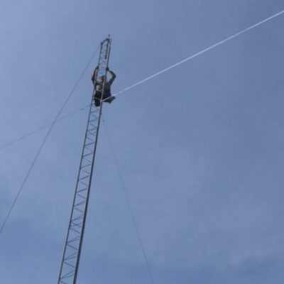 Leonard Smith adjusts the final apex section of the Tower, as it nears completion at 55 feet above ground.