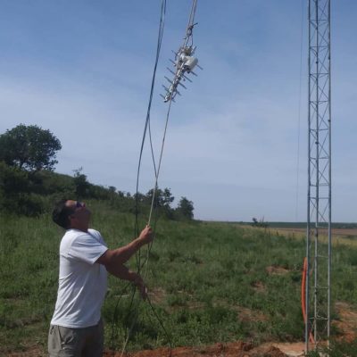 Travis Ridgeway hoists up a rope carrying a small UHF antenna.